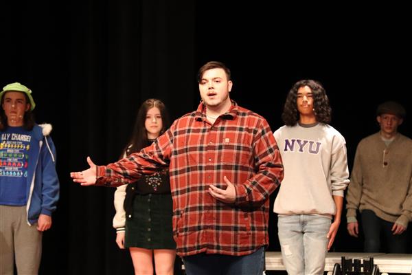 Connor as Mike; ensemble members in background