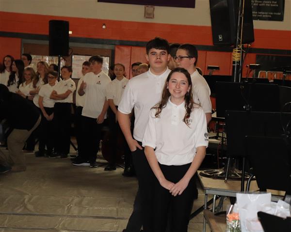 Eighth grade musicians prepare to present flower to family member