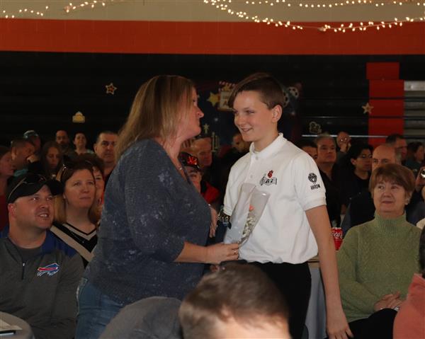 8th Grader giving flower to parent