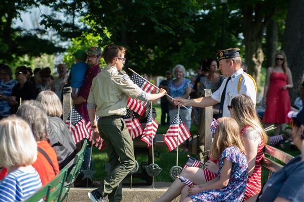 Boy Scout placing flag at war memorial