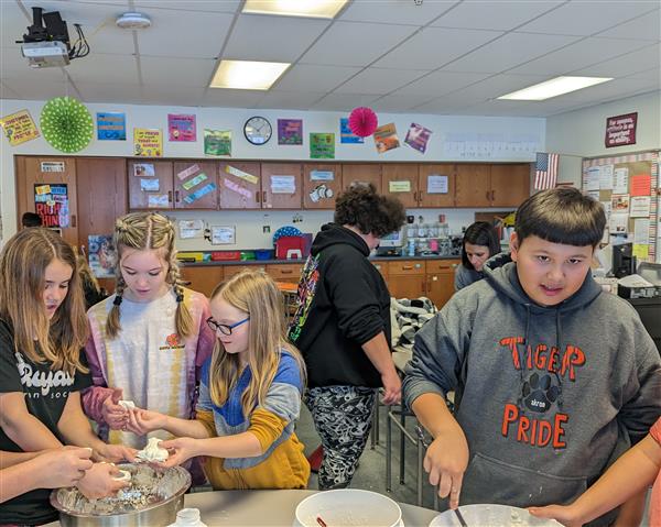 Students mixing cloud dough