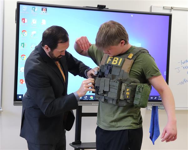 Luke getting fitted with FBI utility vest