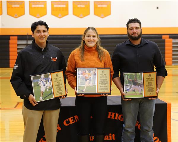 Three inductees with plaques
