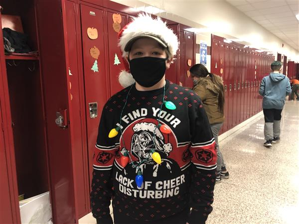 Student wearing holiday sweater and hat