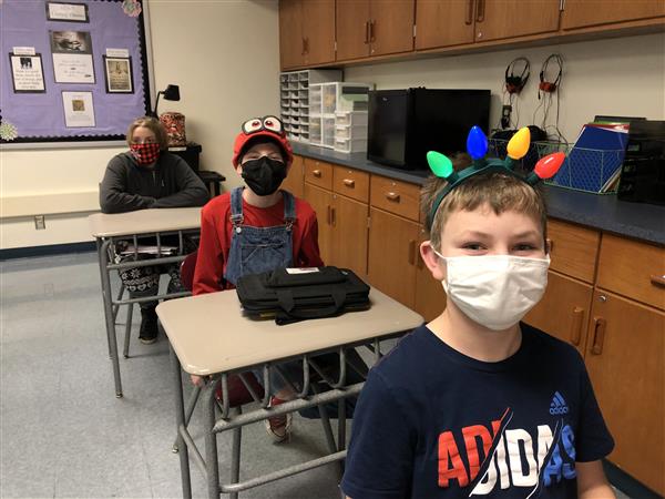 Students at their desks with holiday headgear